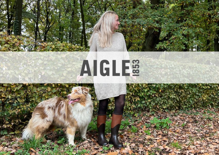 Frau in Gummistiefeln mit Hund