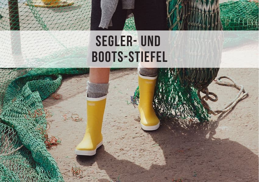 Seglerin mit maritimen Gummistiefeln auf dem Deck eines Segelboots