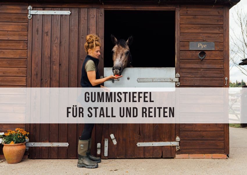 Reiterin mit Gummistiefeln vor dem Stall Pferdestall