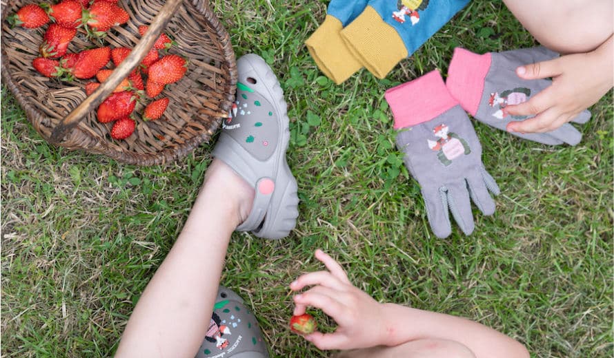 Kind mit Gummischuhen und Clogs
